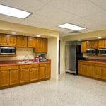 large office kitchen with multiple microwaves and ample cabinetry