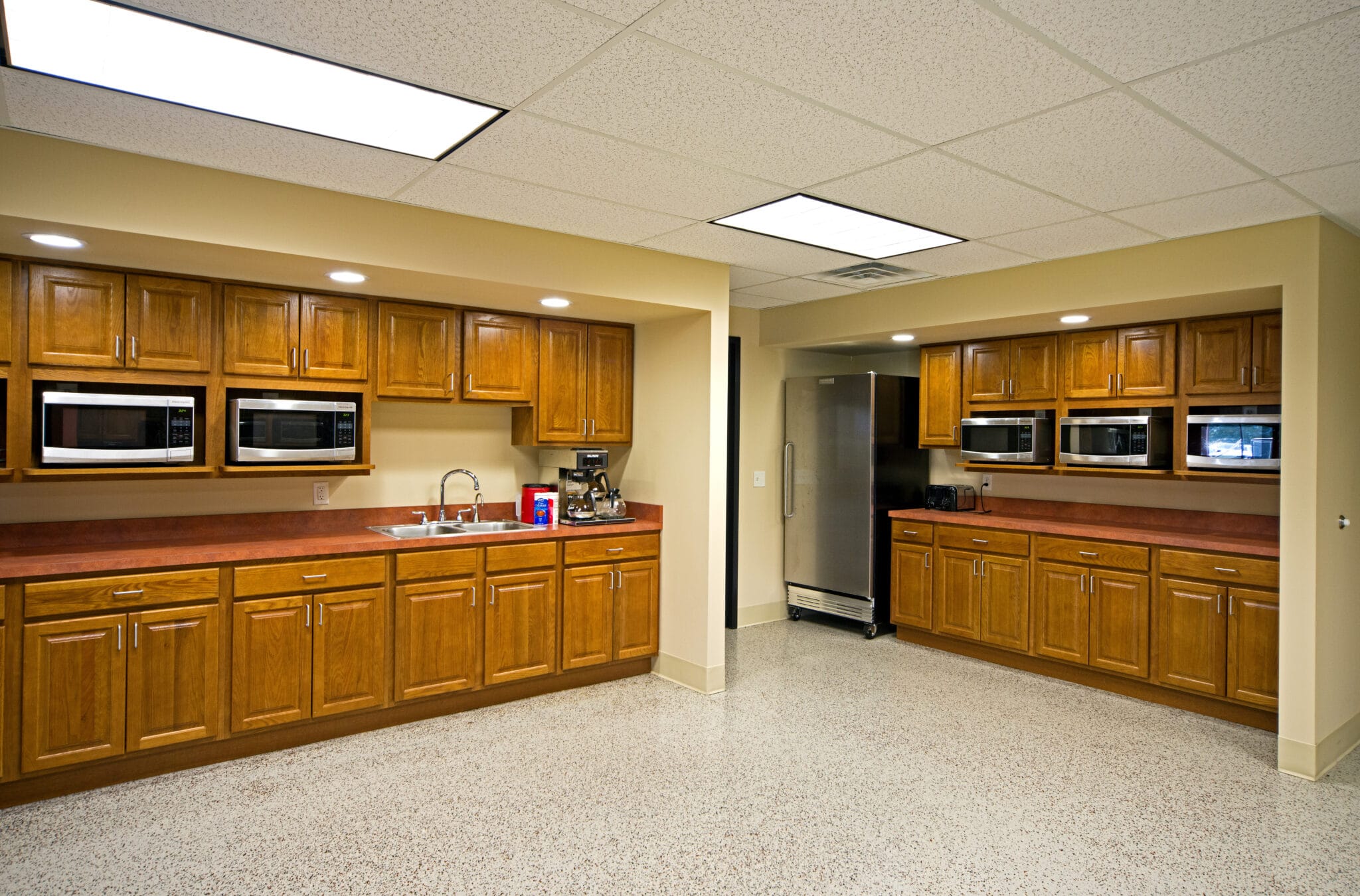 large office kitchen with multiple microwaves and ample cabinetry