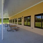 covered concrete patio with picnic tables