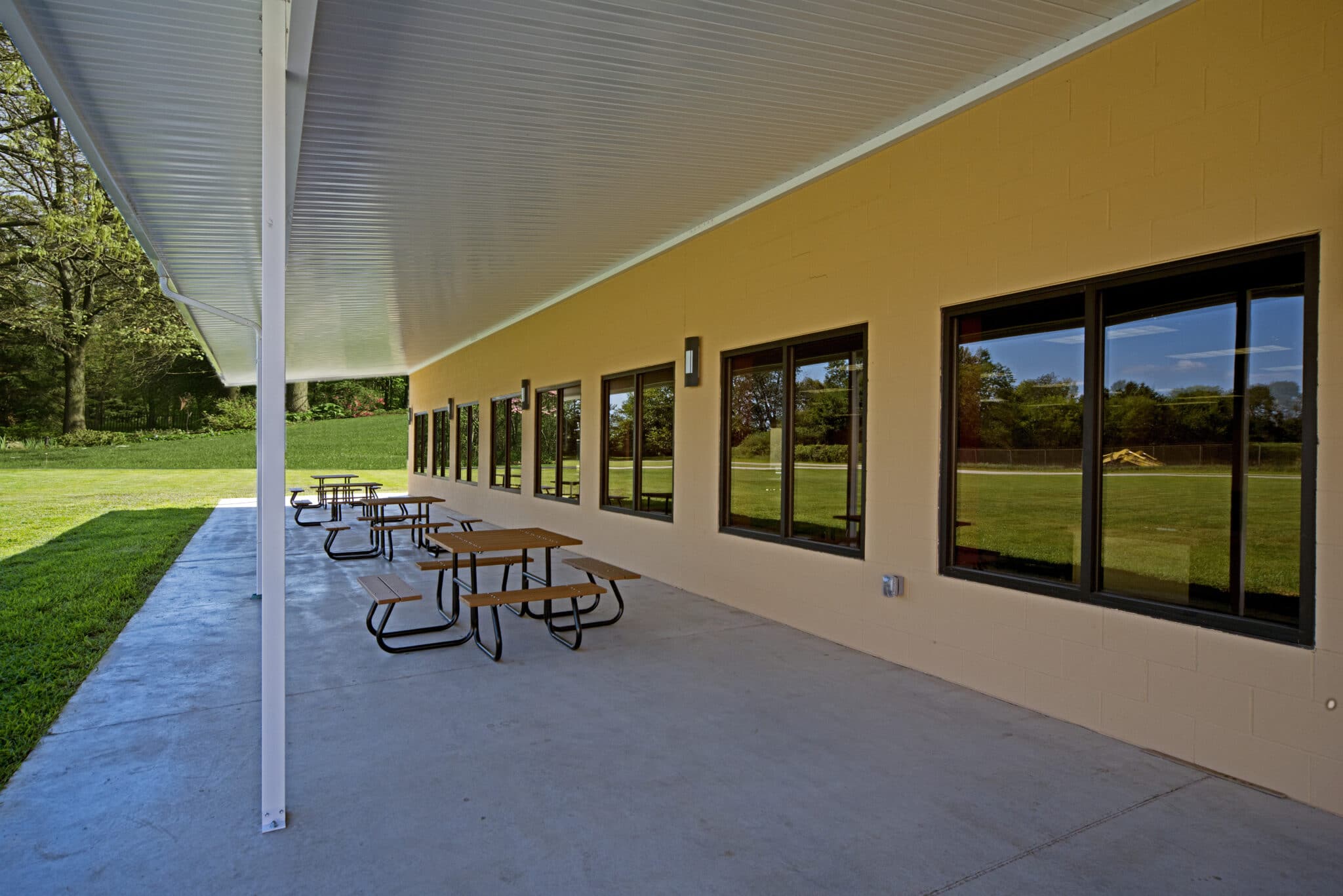 covered concrete patio with picnic tables