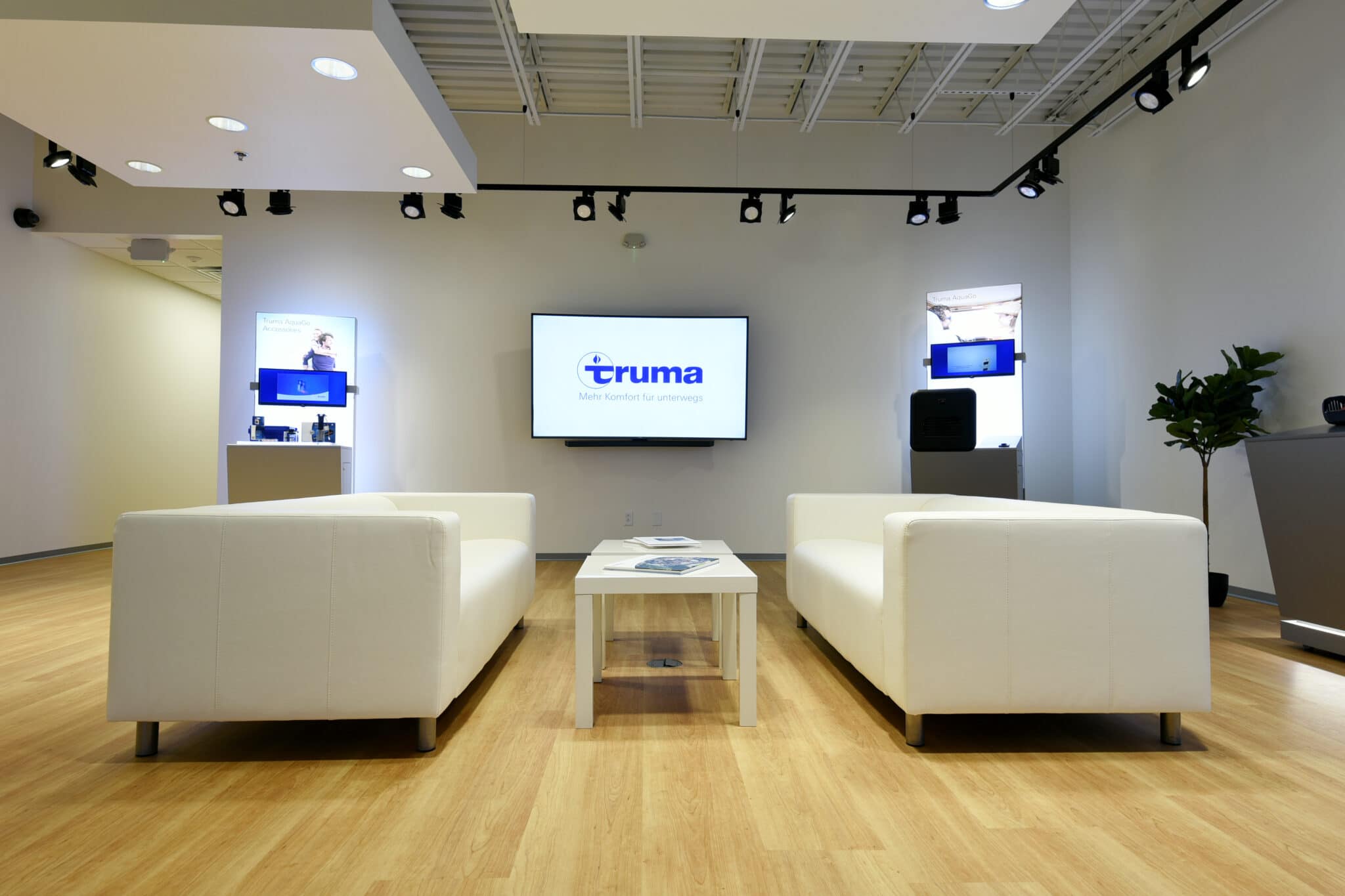 minimalist lobby with white couches and coffee table at Truma Corporation