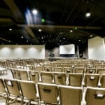 inside church auditorium with stage and exposed ductwork