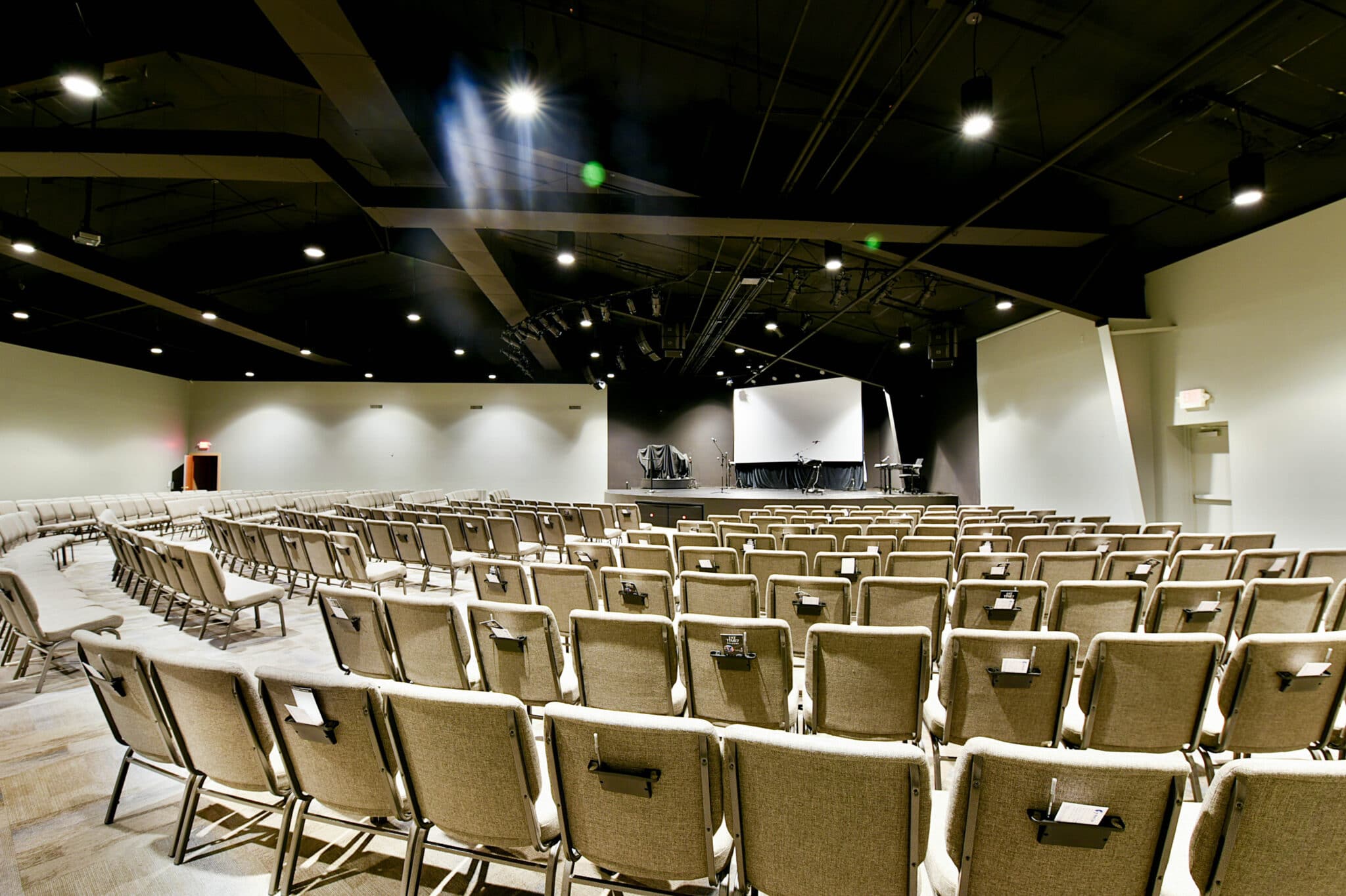 inside church auditorium with stage and exposed ductwork