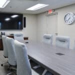 conference room with comfortable chairs, large table, and television