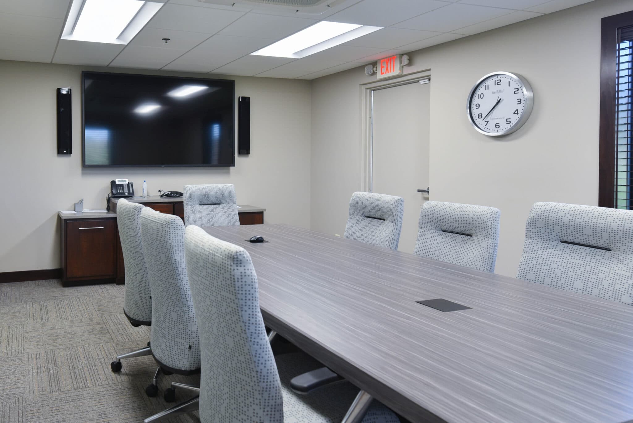 conference room with comfortable chairs, large table, and television