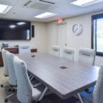 conference room with comfortable chairs, large table, and television