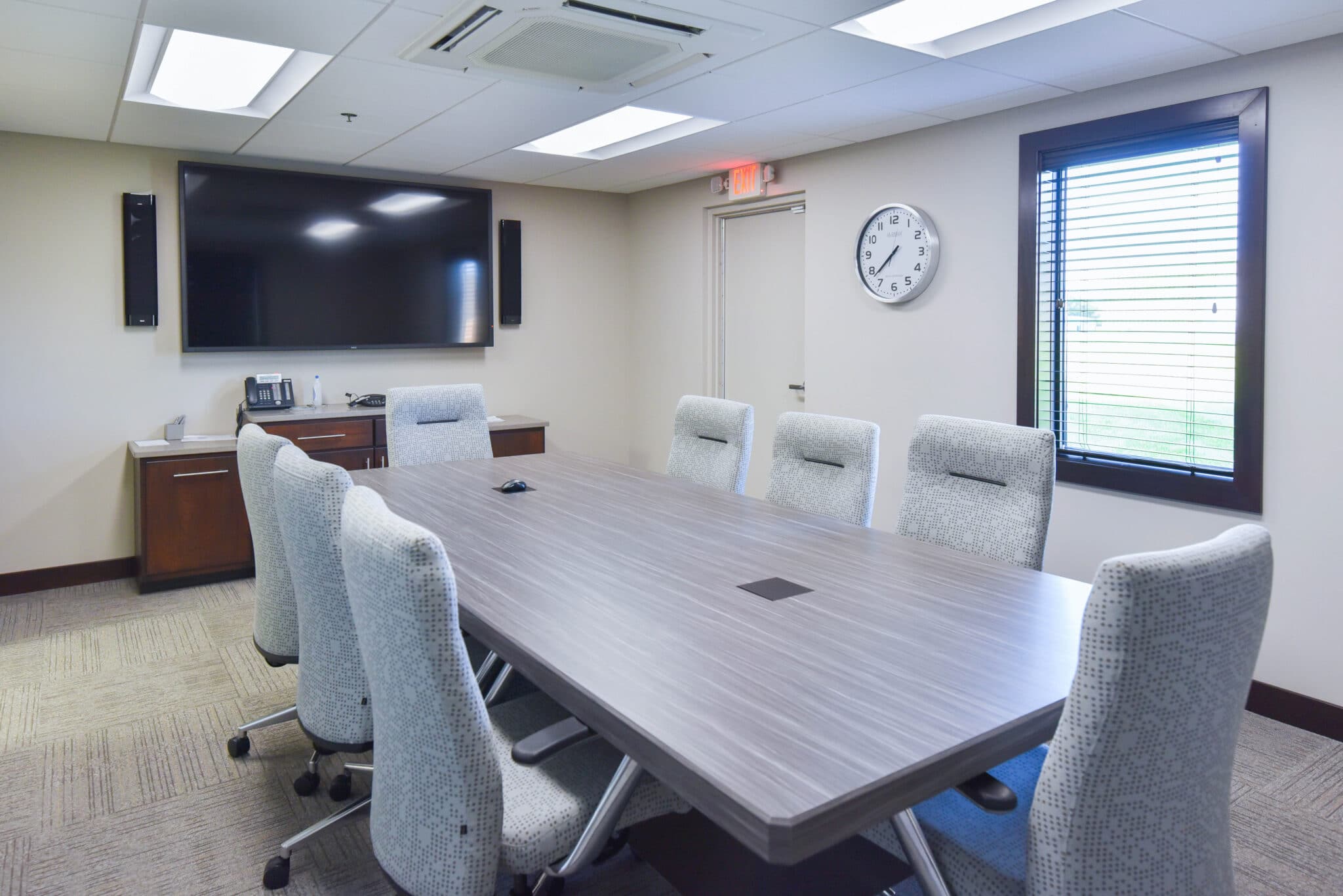 conference room with comfortable chairs, large table, and television