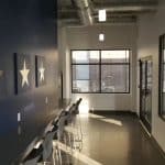 sunlit hallway with blue accent wall and a bar with stools