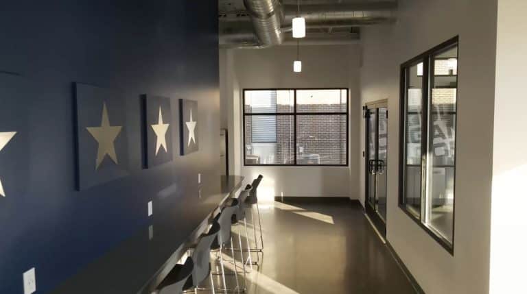 sunlit hallway with blue accent wall and a bar with stools