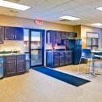 fully stocked office breakroom with high top tables