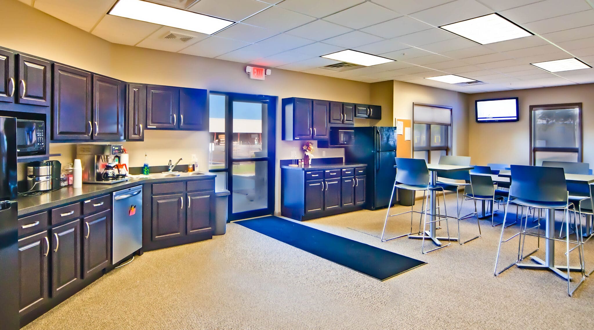 fully stocked office breakroom with high top tables