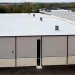 exterior wall of pre-engineered metal building with tall windows and metal siding