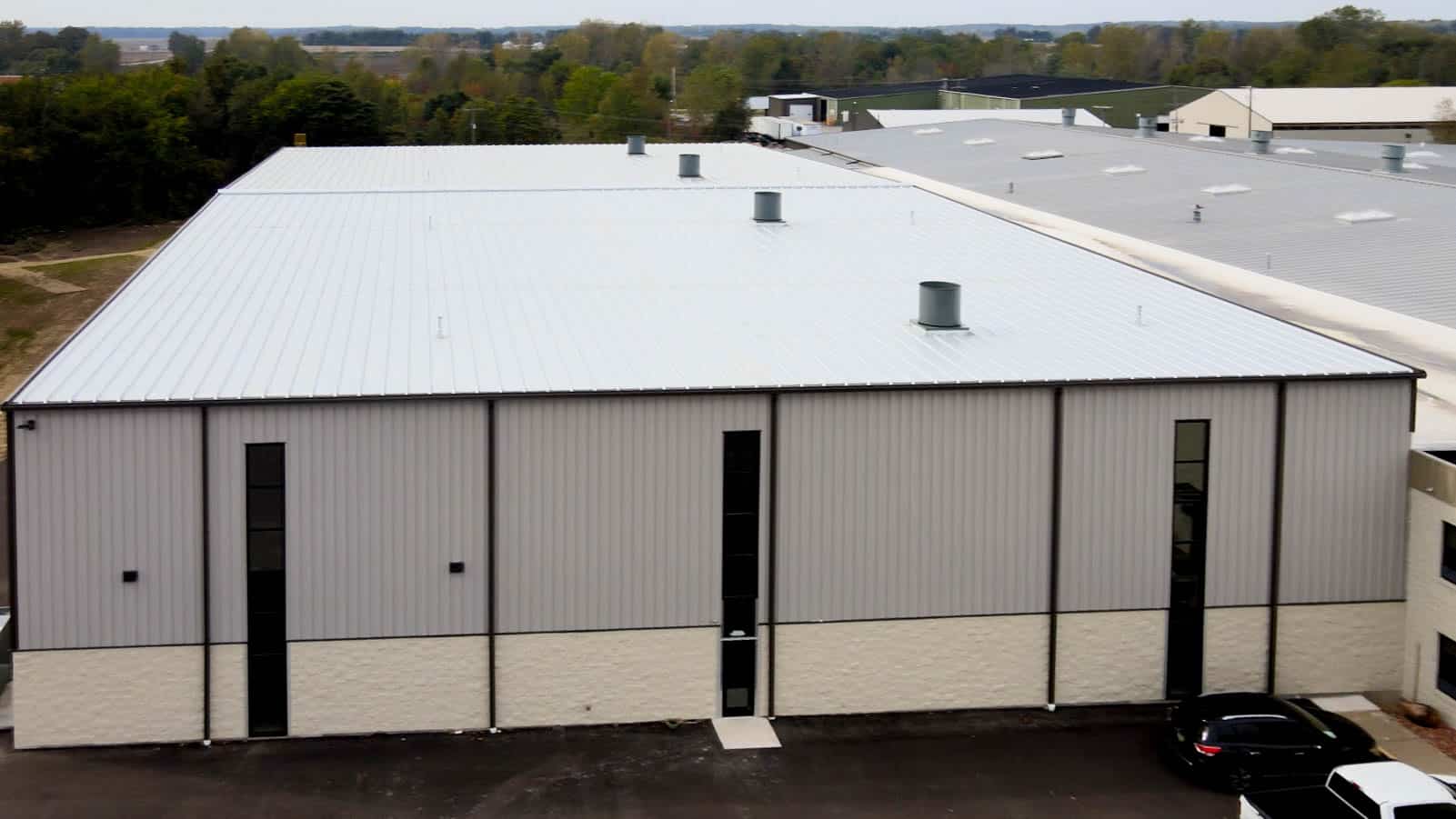 exterior wall of pre-engineered metal building with tall windows and metal siding