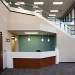 office lobby with beige walls and glass staircase railing