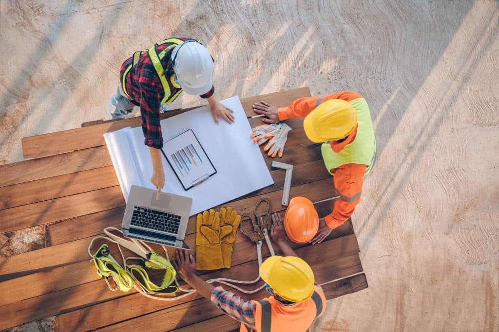 Team of engineer and architects working, meeting, discussing,designing, planning, measuring layout of building blueprints at construction site, Top view,