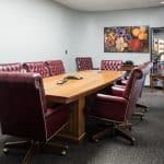 conference room with large red upholstered chairs and wooden table