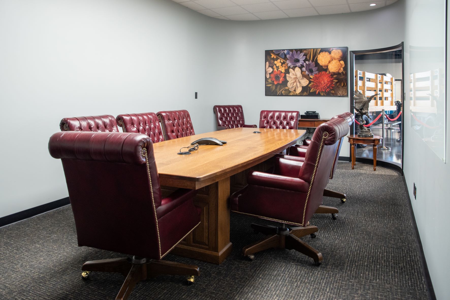 conference room with large red upholstered chairs and wooden table