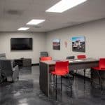 employee break room with high top table, recliners, and tv