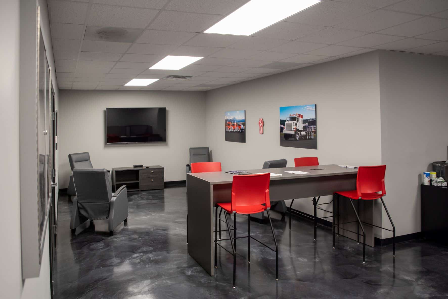 employee break room with high top table, recliners, and tv