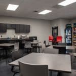 employee break room with kitchenette, tables and chairs, and vending machines