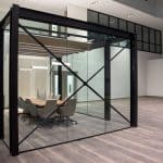 glass-walled conference room with hanging lights and conference table