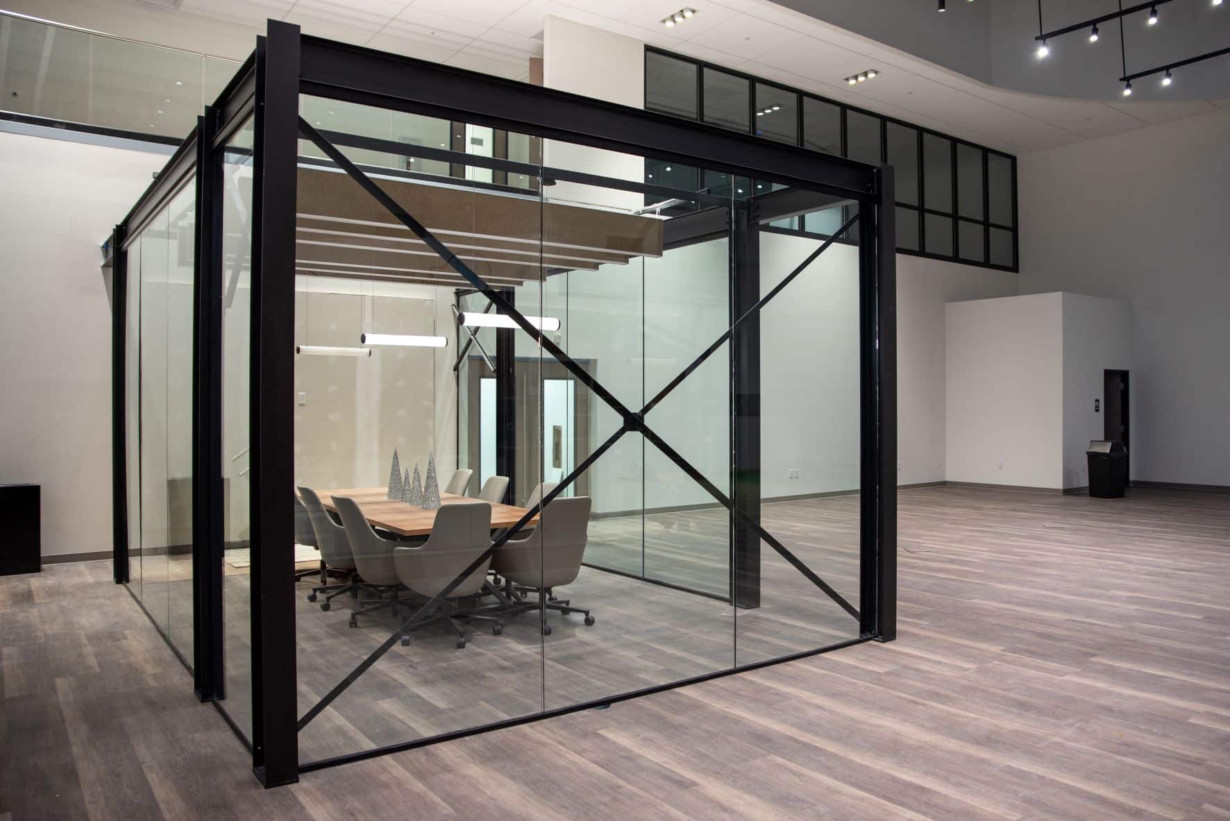 glass-walled conference room with hanging lights and conference table