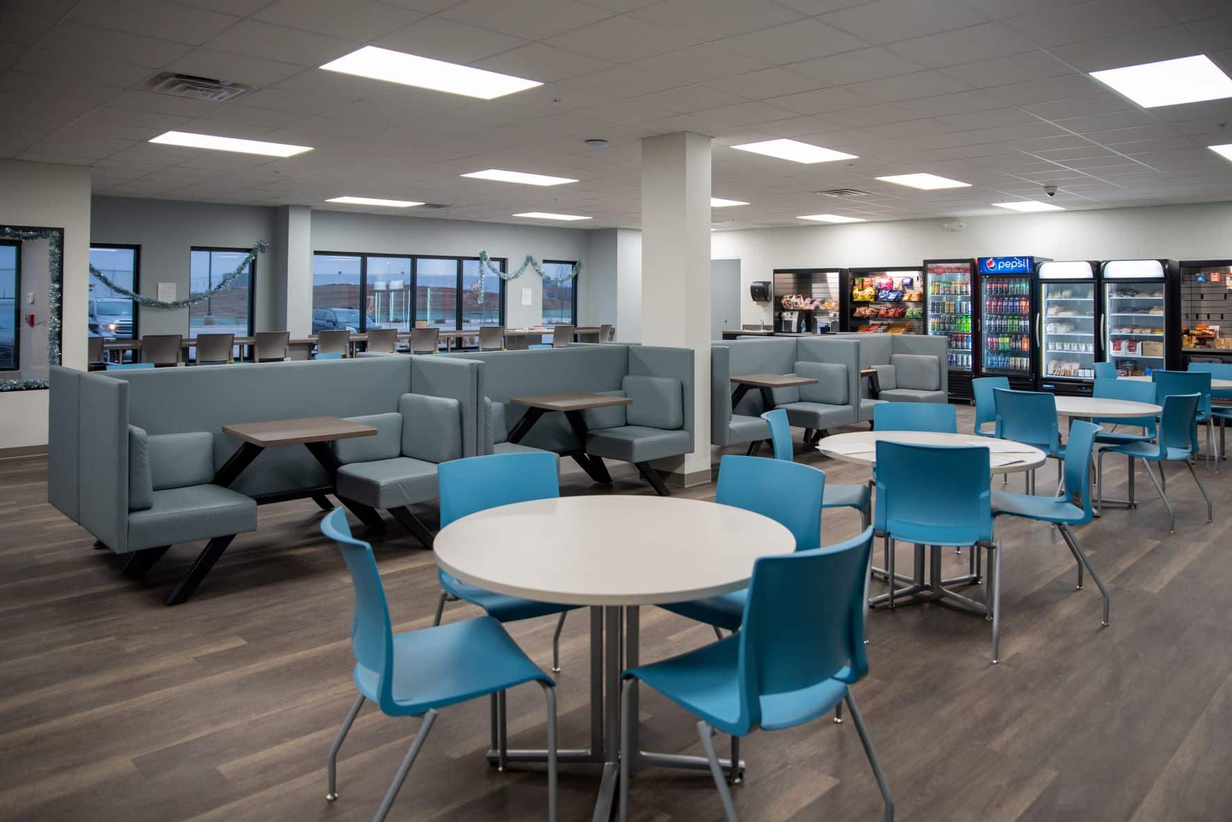 employee breakroom with vending machines, tables and chairs, and booth seating