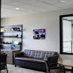 Office lounge at Whiteford Kenworth Toledo with leather sofa, shelving with truck models, and Kenworth wall art.