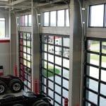 View of service bay at Whiteford Kenworth Toledo with large glass overhead doors and truck chassis inside.