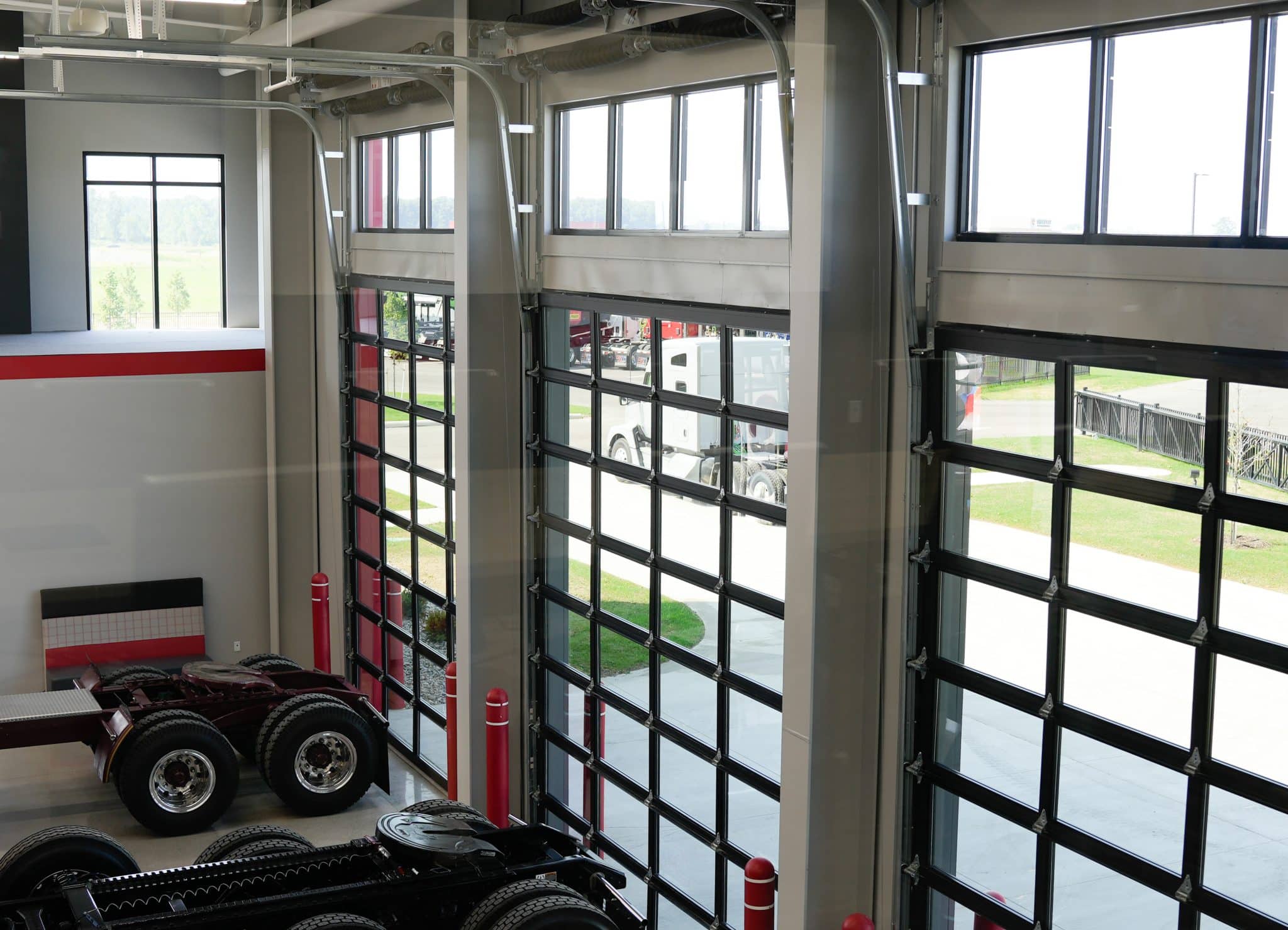 View of service bay at Whiteford Kenworth Toledo with large glass overhead doors and truck chassis inside.