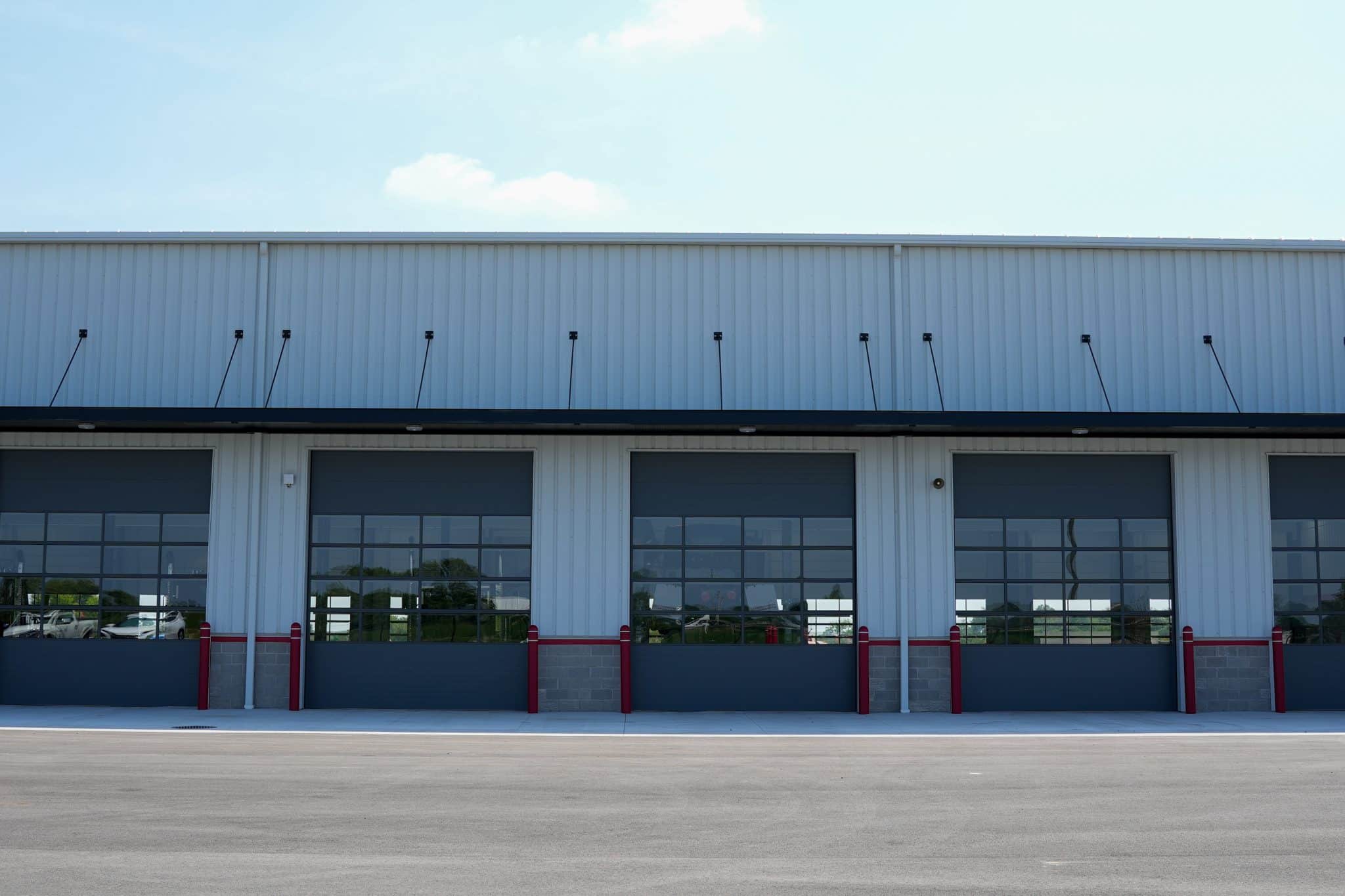 Row of service bay doors at Whiteford Kenworth Toledo metal building with overhead garage doors and red bollards.